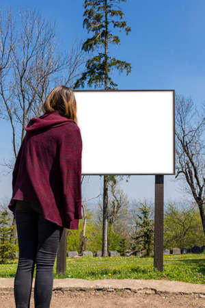 Woman looking at signboard with white blank board for copy space. Add text, photo, informationの写真素材