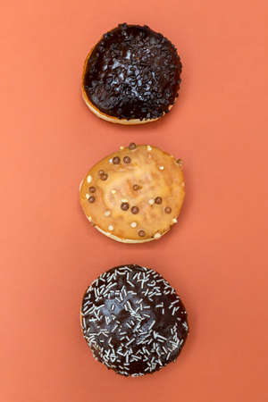 Delicious glazed chocolate donuts on vibrant backgroundの写真素材