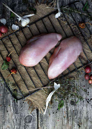 Fresh raw chicken breast with herbs and spices in the kitchen. Top view