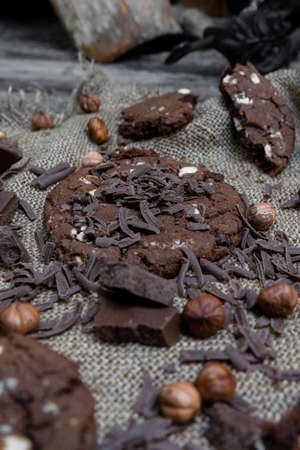 Chocolate cookies with hazelnuts , cocoa and pieces of dark chocolate on the rustic kitchen table