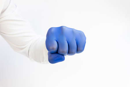 Hand , fist in blue latex Glove ready to punch. White background. Copy spaceの写真素材