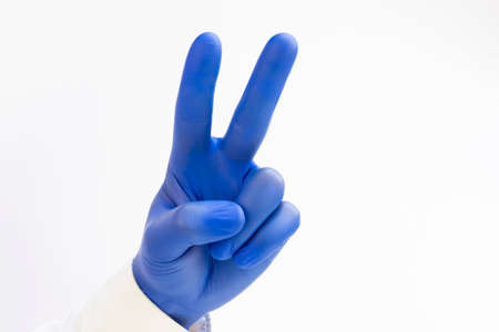 Hand in blue latex Glove raising two fingers up on hand it is shows peace strength fight or victory...