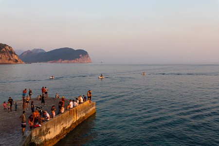 Petrovac ,Montenegro - August 23, 2021: People at the docks relaxing and enjoying beautiful sunset at adriatic seaのeditorial素材