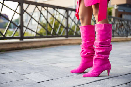 Sexy female legs in high leather boots and short dress. Fashion and glamourの写真素材