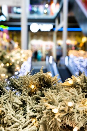 Christmas lights and pine branches decoration in shopping mall. Focus on the decoration with blured backgroundの写真素材