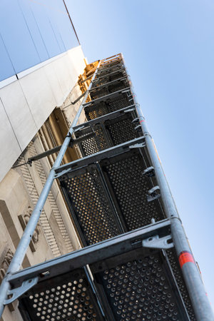 Scaffold mounted on a glass building at the construction siteの写真素材