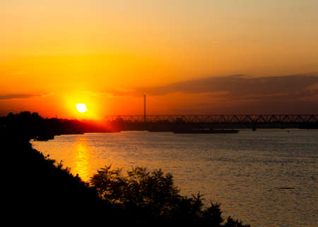 View of a Danube river and bridge in the distance at sunsetの写真素材