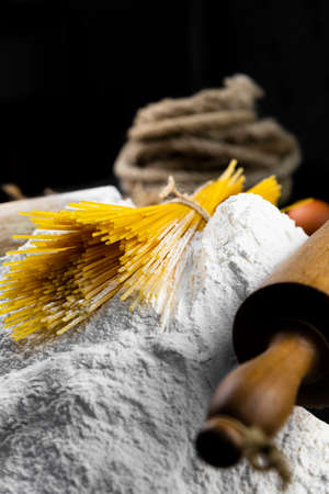 Fresh uncooked Spaghetti and pasta ingredients on a rustic table. Italian cusine and cooking conceptの写真素材