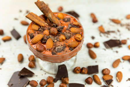 Smoothie or pudding with chocolate, hazelnuts and almonds served in a crystal bowl for breakfast