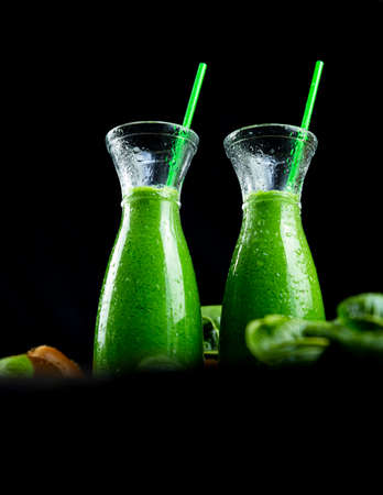 Healthy green smoothies with spinach, apple, kiwi, broccoli and mint in glass jar with fruits and vegetables on the wooden table. Detox, diet, healthy, vegetarian food conceptの写真素材
