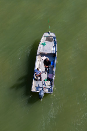 Belgrade, Serbia - April 25 2022 : Fishing boat with fishermen fishing at the river Sava in Belgrade, Serbiaのeditorial素材