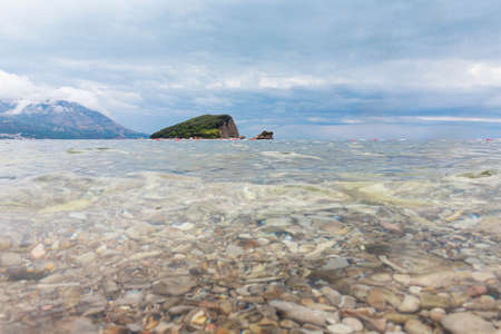 Budva, Montenegro - August 26, 2021: Island called Sveti Nikola (St. Nicholas) near town of Budva. Luxury travel destination with beatuiful beach called Hawaii at Adriatic seaの写真素材