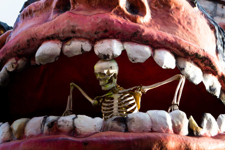 Vienna, Austria - August 16, 2019 :  Skeleton human size figure inside of a giant monsters mouth in...