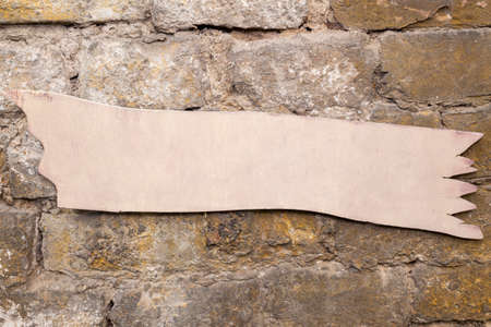 Wooden sign hanging on a rustic brick wall. Emty space, add text or logoの写真素材