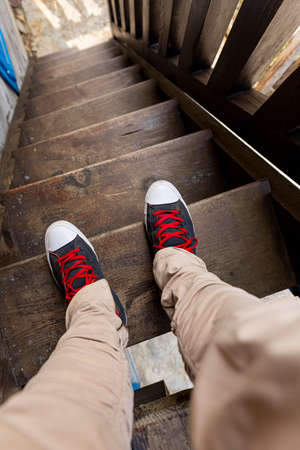 Man walking down the stairs wearing modern sneakers. Point of view. Top view image