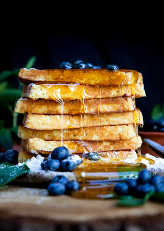 Waffles with fresh blueberries and honey on the rustic table. Freshly baked Belgian waffles