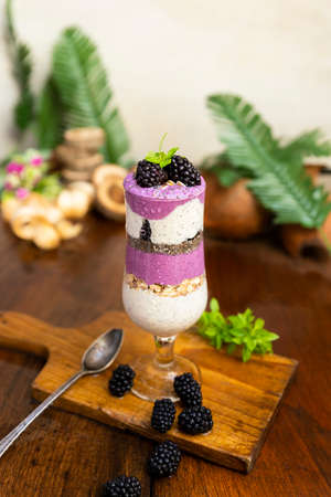 Blackberry smoothies with chia seeds in glass with fresh berries and mint on rustic wooden tableの写真素材
