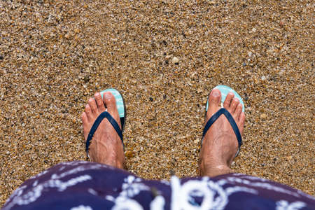 Mans feet in flip-flops at the beach. Top view. Flat lay. Copy space, Add textの写真素材