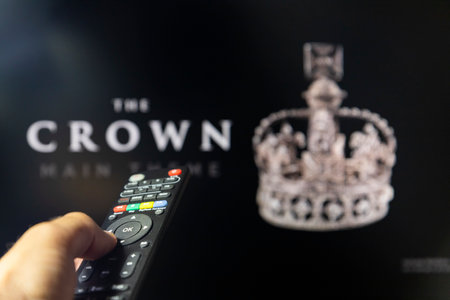 Belgrade, Serbia - September 12, 2022: Watching TV Show The Crown on Netflix with remote control in hand.  TV series is about British Royal family and Queen Elizabeth IIのeditorial素材