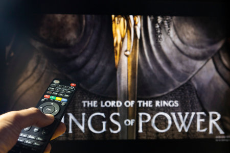 Belgrade, Serbia - September 12, 2022: The Lord of the Rings: The Rings of Power TV series on TV with remote control in hand. Focus on the remote control. Story takes place thousands of years before the events of J.R.R. Tolkien's 'The Hobbit' and 'The Lorのeditorial素材