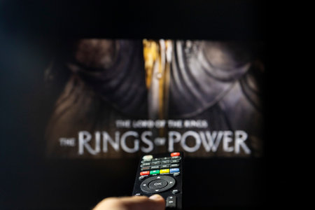 Belgrade, Serbia - September 12, 2022: The Lord of the Rings: The Rings of Power TV series on TV with remote control in hand. Focus on the remote control. Story takes place thousands of years before the events of J.R.R. Tolkien's 'The Hobbit' and 'The Lorのeditorial素材