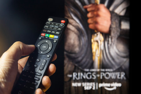 Belgrade, Serbia - September 12, 2022: The Lord of the Rings: The Rings of Power TV series on TV with remote control in hand. Focus on the remote control. Story takes place thousands of years before the events of J.R.R. Tolkien's 'The Hobbit' and 'The Lorのeditorial素材