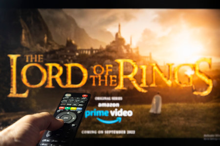 Belgrade, Serbia - September 12, 2022: The Lord of the Rings: The Rings of Power TV series on TV with remote control in hand. Focus on the remote control. Story takes place thousands of years before the events of J.R.R. Tolkien's 'The Hobbit' and 'The Lorのeditorial素材
