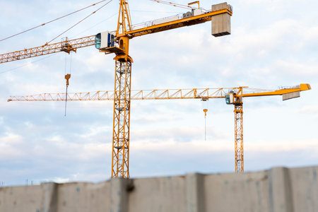 Construction crane with cloudy sky background.