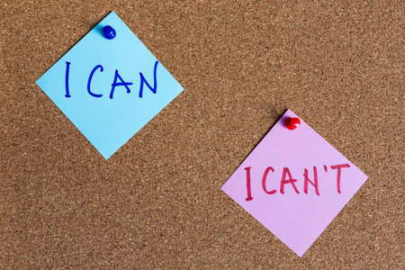 I can and I can't phrases written on sticky notes pinned at cork boardの写真素材