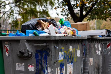 Belgrade, Serbia - November 02, 2022: Dumpster full of trash. Garbage falling all over. Stop...