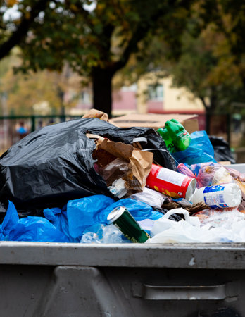 Belgrade, Serbia - November 02, 2022: Dumpster full of trash. Garbage falling all over. Stop...