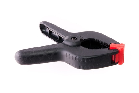 Black plastic A-clamp with wooden brick isolated on white