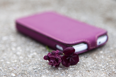 White cell phone in a case with a matching color flowerの写真素材