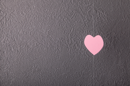 Pink paper Saint Valentines hearts on grey wall texture backgroundの写真素材