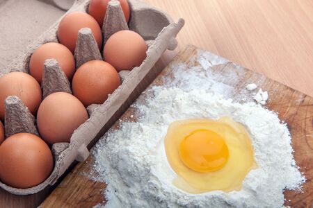Egg white and yolk in floor with whip on the kitchen tableの写真素材