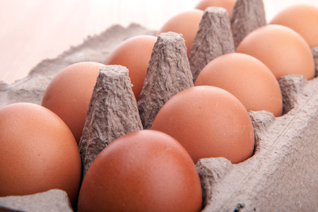 brown eggs in egg carton on the kitchen tableの写真素材