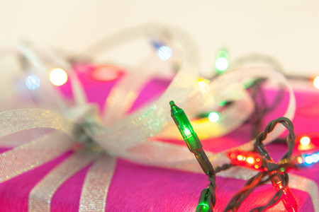 Christmas lights and packaged gift with soft focus backgroundの写真素材