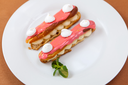 Pair of decorated exquisite cream dessert eclairs