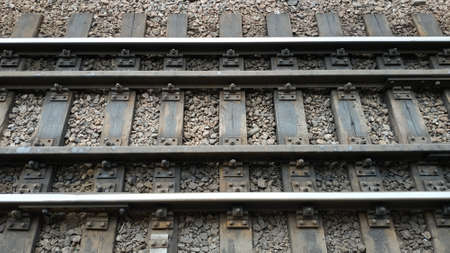 fastened rails and sleepers on a loose road with stones