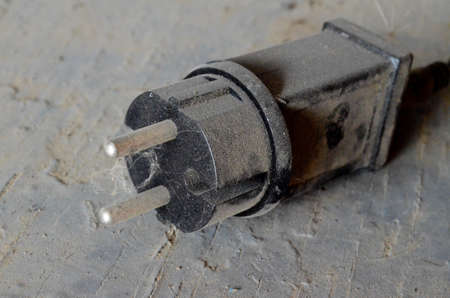 wide black plastic plug for a dust layer socket on a wooden surface