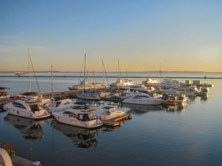Ukraine, Odessa, Marine Station, Yacht Complex. June 17, 2012. The Rays of the Dawn Sun Tinted the Moored Yachts with A Golden Hueのeditorial素材