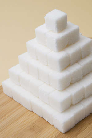 Sugar cubes pyramid on a yellow basckgroundの写真素材