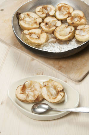 Baked apples in a frying pan and on a plateの写真素材