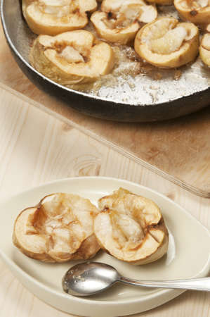 Baked apples in a frying pan and on a plateの写真素材