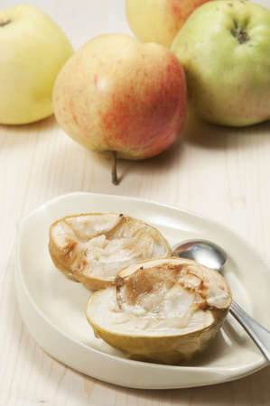 Baked apples on a plate and fresh applesの写真素材