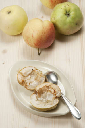 Baked apples on a plate and fresh applesの写真素材