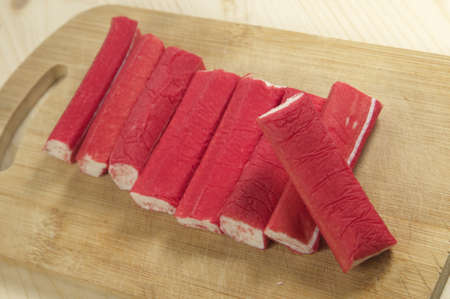 Crab sticks on a board on a wooden tableの写真素材
