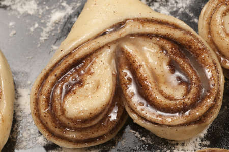 Cinnamon buns ready for baking on a cookie sheet