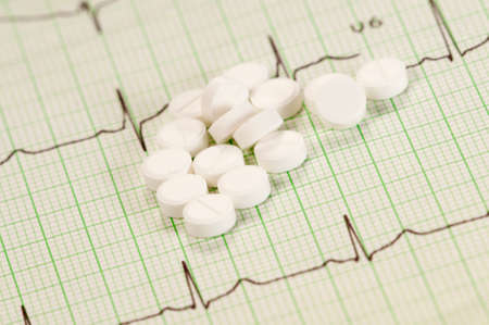 Tablets on electrocardiogram paper, closeup shot, local focusの写真素材