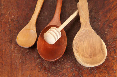 Wooden spoons and stick for honey on a timber board, closeupの写真素材